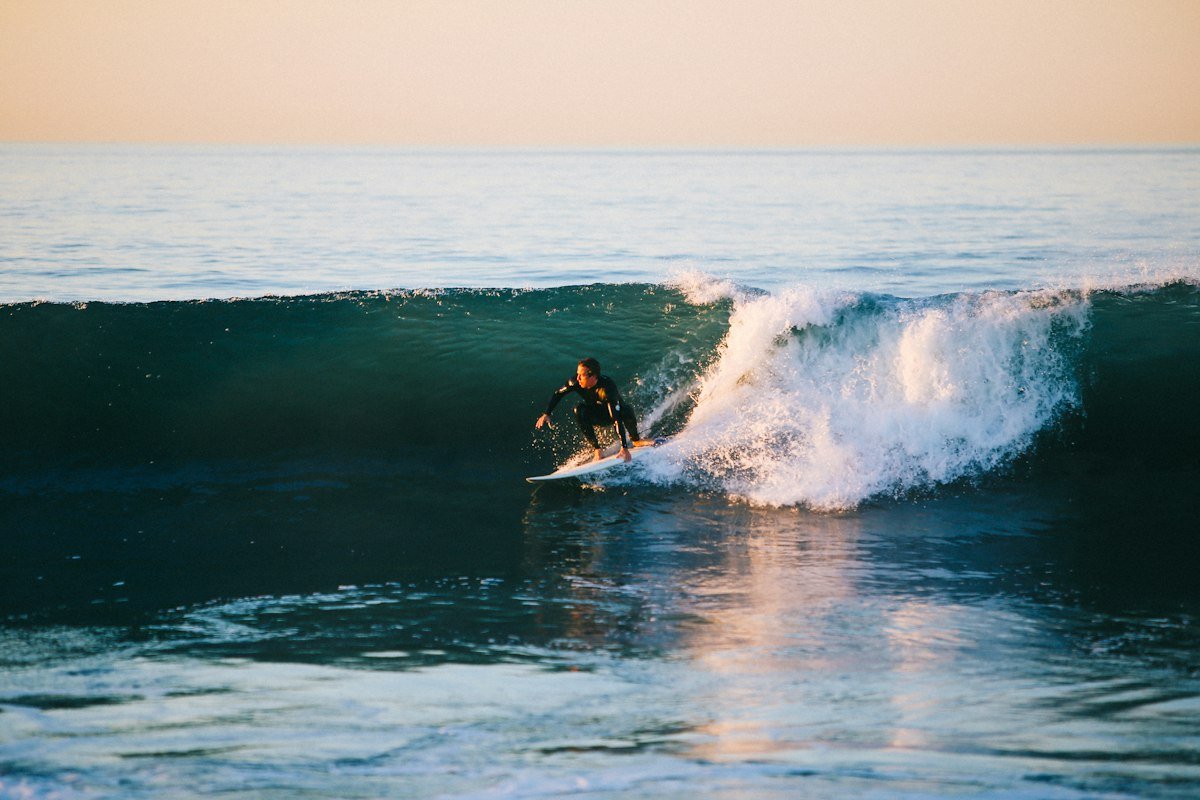 Surfer riding a green wave in the evening