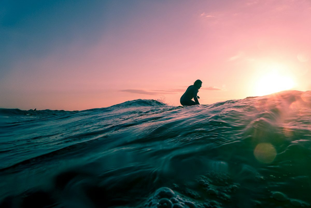 Surfer riding a wave in the golden light of the evening