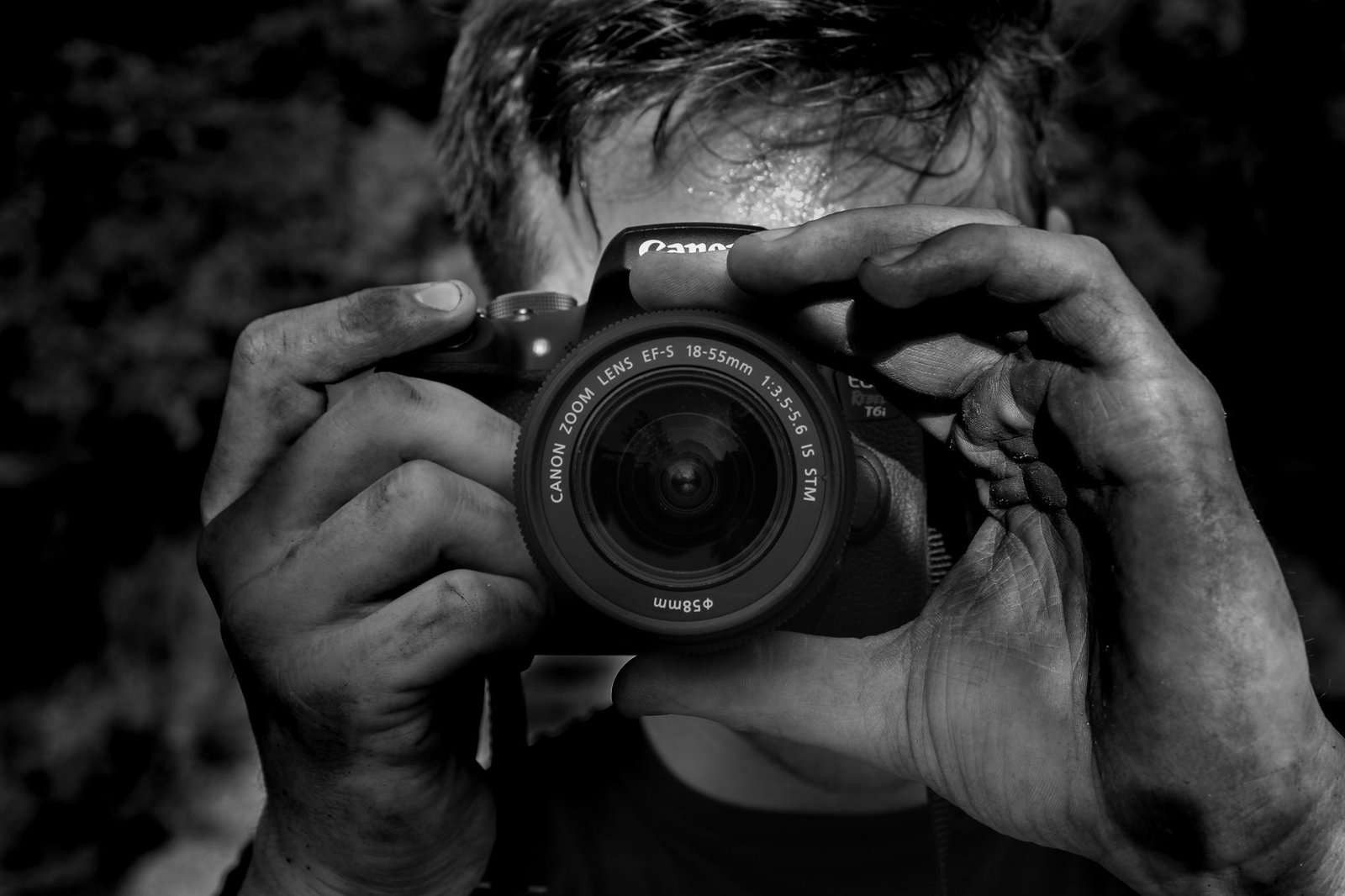 Black and white portrait of a photographer behind his camera