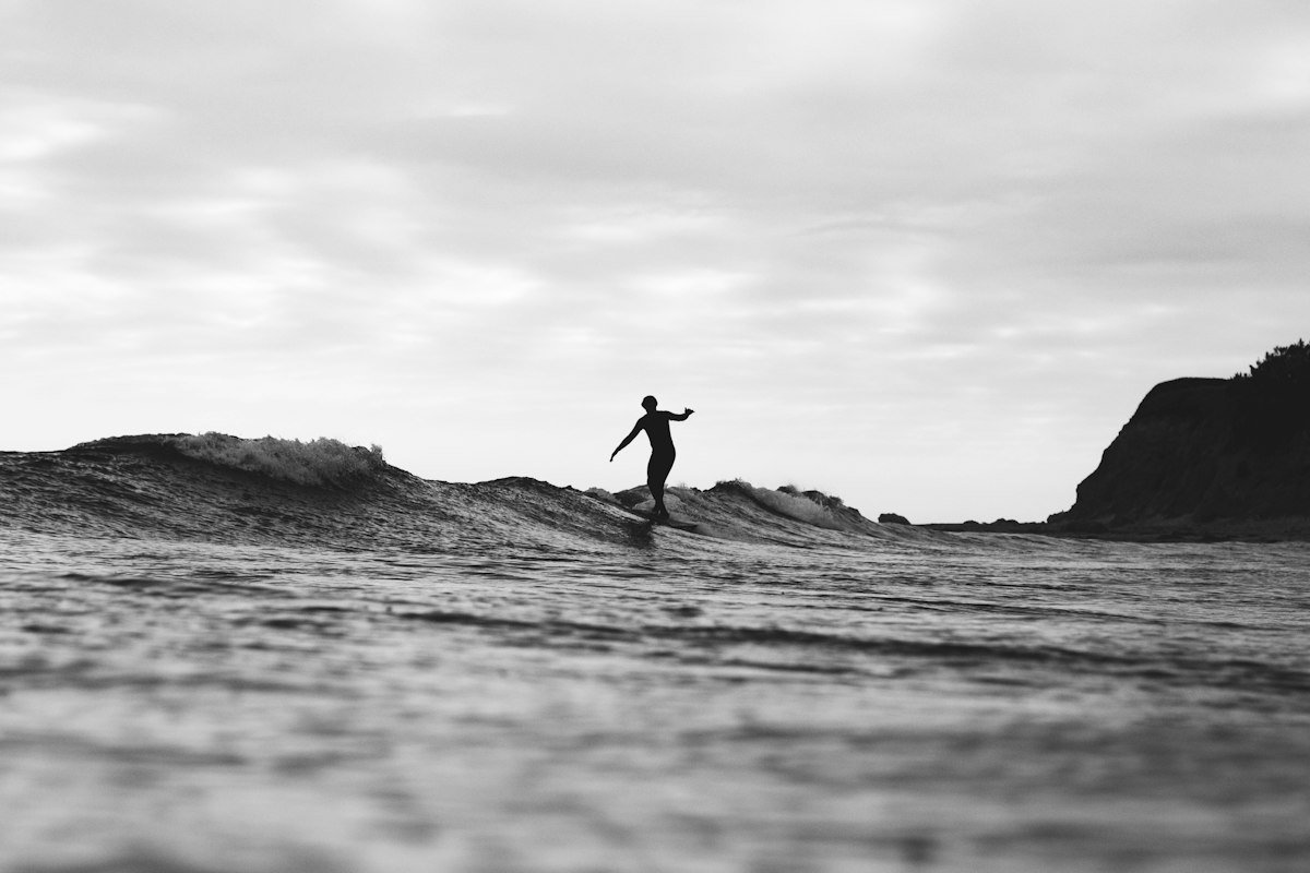 Black and white shot of a surfer on the face of a wave