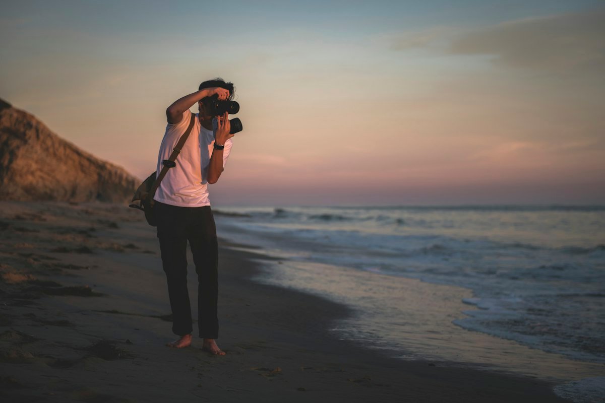 Photographer shooting on the shoreline at sunset