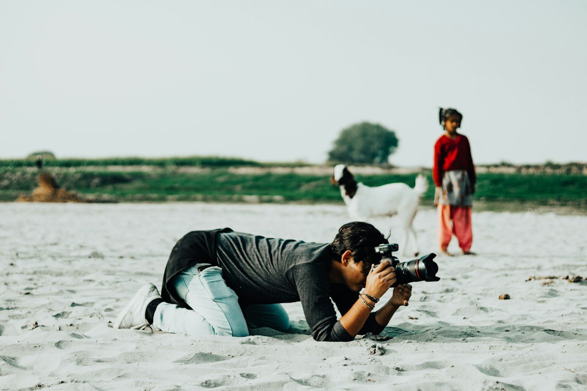 Photographer lying in the sand to frame a shot