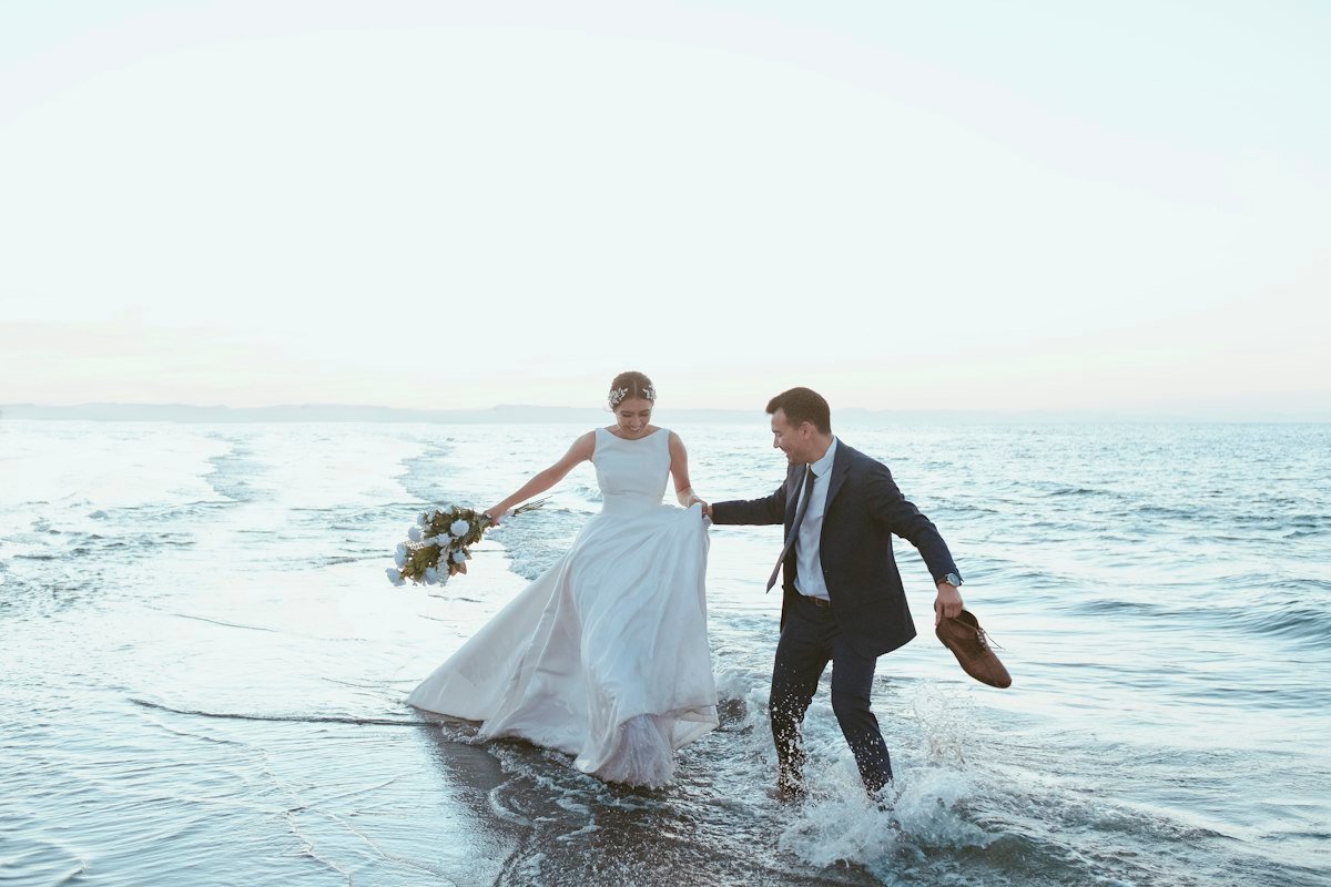 Newlyweds running into the sea