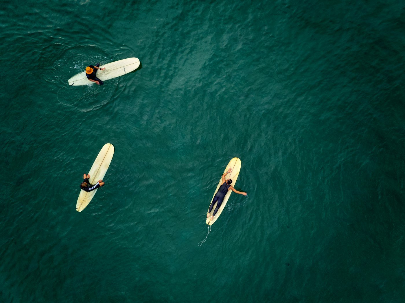 Surfers waiting on their boards in the turquoise water of the bay