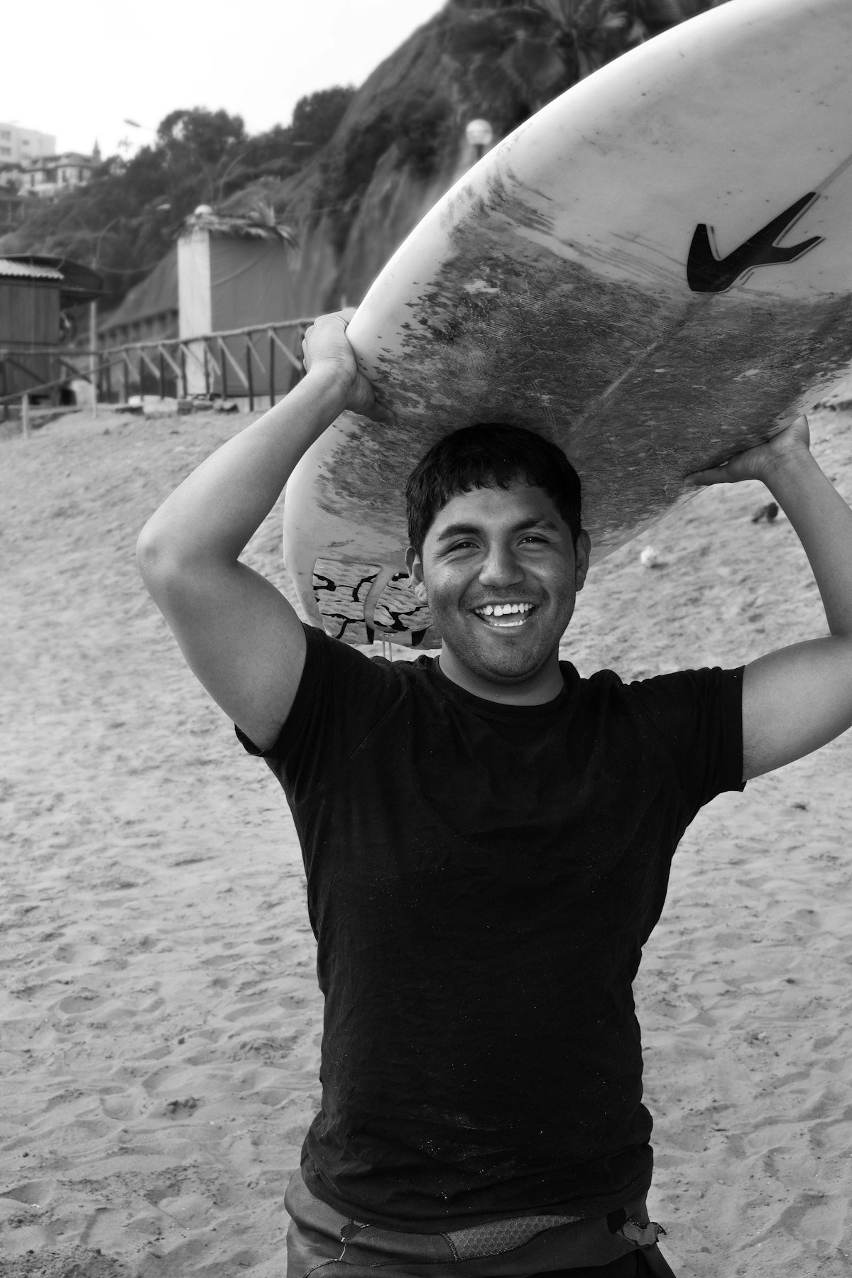Smiling surfer carrying his board after a session